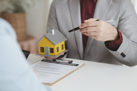 Real estate agents explain models of housing estates in projects to elaborate to clients, explaining and presenting information about homes and purchasing loans. Real estate trading concept.の写真素材