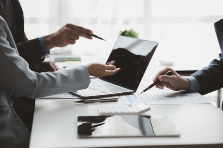 Businessman is reviewing monthly sales documents for analysis and marketing plans for more sales growth, they are the founders of young companies co-founding startups. Sales management concept.の写真素材