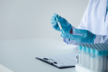 Lab assistant, a medical scientist, a chemistry researcher holds a glass tube through the blood...