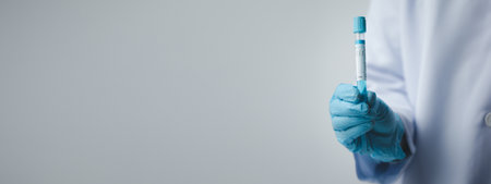 Lab assistant, a medical scientist, a chemistry researcher holds a glass tube through the blood sample, does a chemical experiment and examines a patient's blood sample. Medicine and research concept.の写真素材