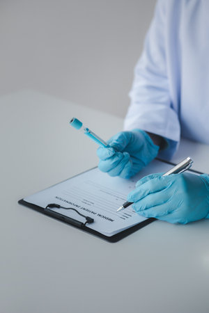 Lab assistant, a medical scientist, a chemistry researcher holds a glass tube through the blood...