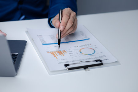 Businessman sits in a private office at his company and is reviewing company financial documents, senior management checking financial information for accuracy. Financial management.の写真素材