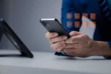 Businessman is holding smartphone with hologram, manipulating smartphone control, manipulating smartphone to suit user's usage.の写真素材