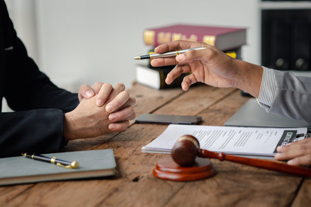 Client was listening to a lawyer advising on an embezzlement case, explaining the details of the proceeding and gathering evidence to file a lawsuit against the defendant. The concept of litigation.の写真素材