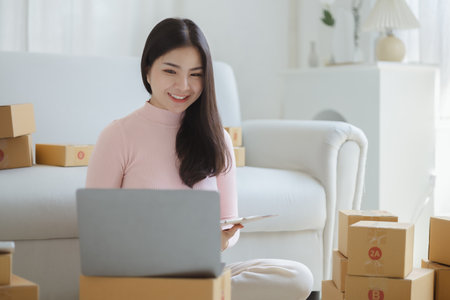 Online Seller, Young Asian store owner, she makes a living selling products online, live selling on social media platforms to reach target audience. Concept of selling products online.の写真素材