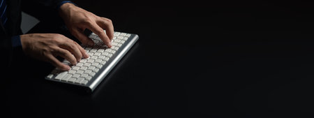 Person typing on a computer keyboard, businessman is working in a startup company's office, he is...