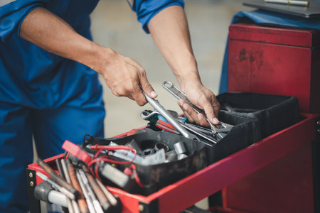 Professional car mechanics searching for auto repair tools in tool racks, all kinds of auto specialists, expert auto repair and accredited auto repair centers.の写真素材