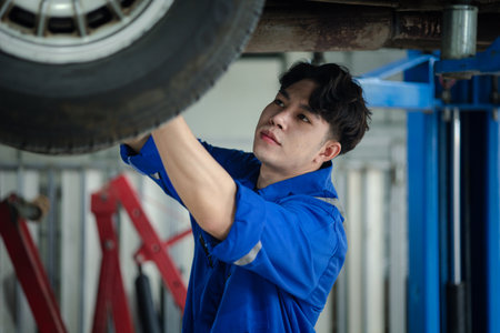Professional car mechanic checking car undercarriage, all types of car specialists, expert auto repair and accredited car repair centers.の写真素材