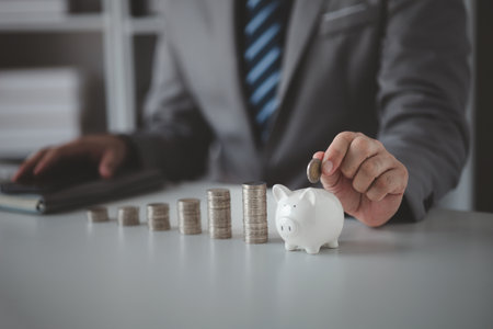 Person with pile of coins and piggy bank, money saving concept for future use and financial stability, salary management, personal finance, investment savings.の写真素材