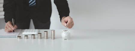 Person with pile of coins and piggy bank, money saving concept for future use and financial stability, salary management, personal finance, investment savings.の写真素材