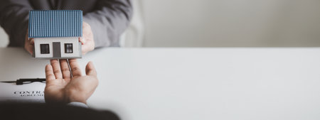 Real estate agents explain models of housing estates in projects to elaborate to clients, explaining and presenting information about homes and purchasing loans. Real estate trading concept.の写真素材