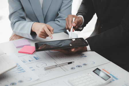 Businessman is reviewing monthly sales documents for analysis and marketing plans for more sales growth, they are the founders of young companies co-founding startups. Sales management concept.の写真素材