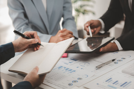 Businessman is reviewing monthly sales documents for analysis and marketing plans for more sales growth, they are the founders of young companies co-founding startups. Sales management concept.の写真素材