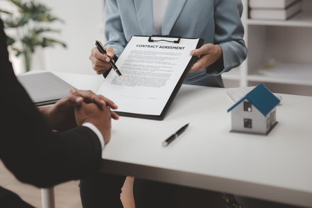 Real estate agents explain models of housing estates in projects to elaborate to clients, explaining and presenting information about homes and purchasing loans. Real estate trading concept.の写真素材