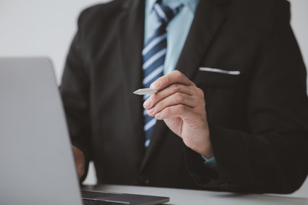 Businessman man with laptop, he uses the laptop to view business documents and communicate sending e-mail messages over the internet. The concept of using technology in communication.の写真素材