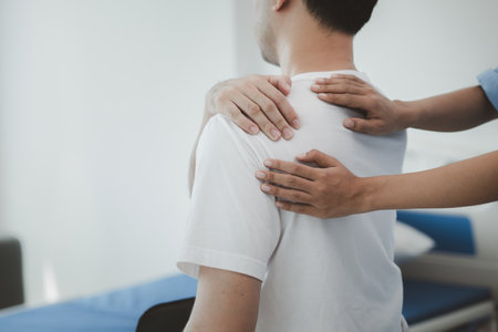 A physiotherapist doing physiotherapy for a patient in a hospital room, physiotherapy helps to recover from illness by moving the body and muscles. The concept of treating illnesses with physical therapy.の写真素材