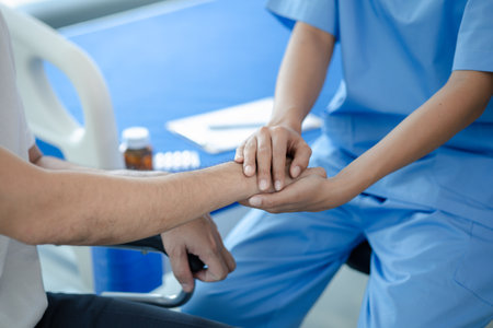Male patient sitting in wheelchair undergoing a medical examination with specialist physician, treating injuries Getting medical treatment from specialist doctor can get the right and proper treatmentの写真素材