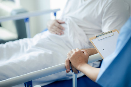 Patient on an inpatient hospital bed with a doctor examining and asking for information about the symptoms in order to diagnose the correct and appropriate treatment. The concept of medical treatment.の写真素材