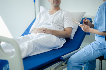 Patient on an inpatient hospital bed with a doctor examining and asking for information about the symptoms in order to diagnose the correct and appropriate treatment. The concept of medical treatment.の写真素材