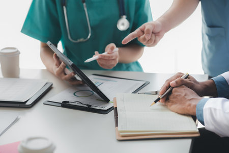 A conference room in a hospital where a group of doctors are attending a meeting, a meeting of executive doctors and chiefs meeting with pharmaceutical dealers. Doctor meeting concept.の写真素材