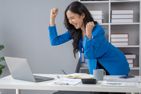 Beautiful Asian woman looking at data and showing happy expression, businesswoman is delighted to see the quarterly earnings summary on target. Management concept of a startup company.の写真素材