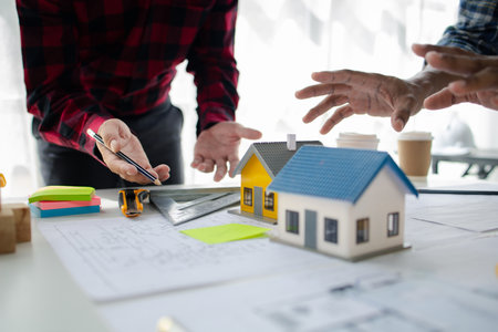 The home design architects are reviewing the house plan draft, the project commissioned by the client, and the custom design before delivery. Interior design and decoration ideas.の写真素材
