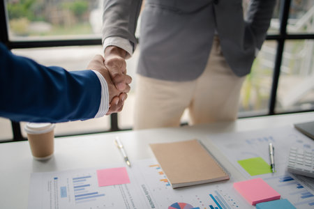 Two business men shake hands, Two businessmen are agreeing on business together and shaking hands after a successful negotiation. Handshaking is a Western greeting or congratulation.の写真素材