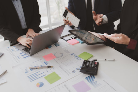 Businessman is reviewing monthly sales documents for analysis and marketing plans for more sales growth, they are the founders of young companies co-founding startups. Sales management concept.の写真素材