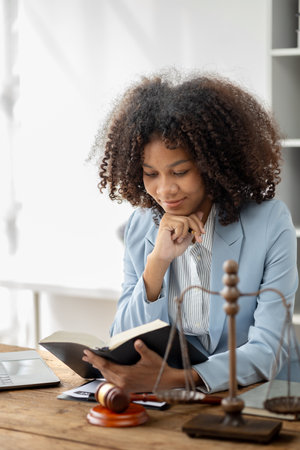 American woman is legal litigation attorney, Female lawyer is in a law firm drafting contracts and reading client case details to study and find a solution to win the case. Lawyer and justice concept.の写真素材