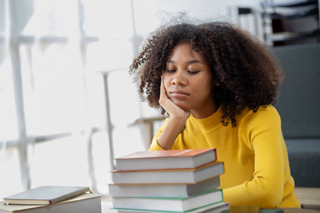 An American woman sits in the living room on weekends, with stacks of books, she is reading and studying for exams. Student concept, students reading, studying.の写真素材
