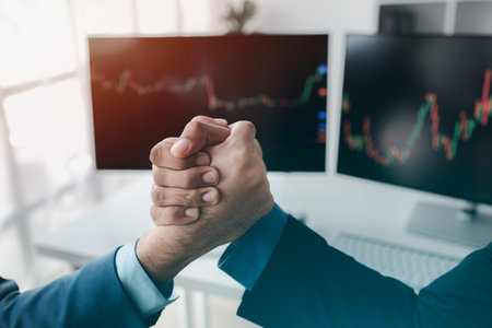 Stock investors shaking hands, business man trading stocks for profit, stock market oscillating graph screen, investment management, analyzing profit trading in stocks.の写真素材