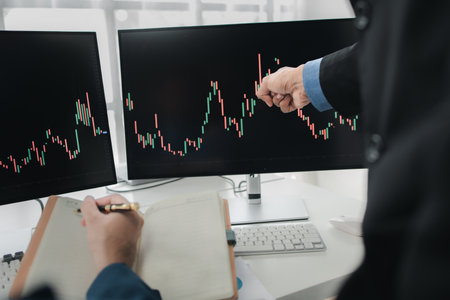 Two stock investors with stock market graph screen, stock fluctuation analysis, business man trading...