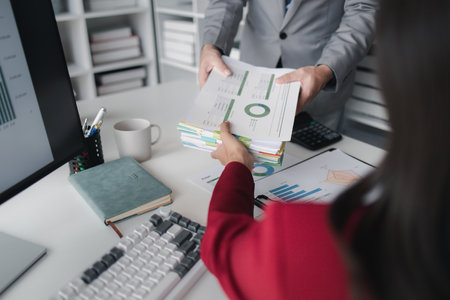 Two company employees handing over papers to each other, marketing staff handing over marketing...