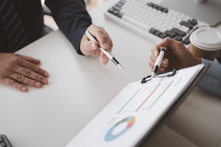 Two people looking at datasheets of marketing and sales results, analysis of business results jointly between executives, department heads and employees to brainstorm company sales management.の写真素材