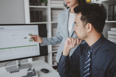 Two people looking at datasheets of marketing and sales results, analysis of business results jointly between executives, department heads and employees to brainstorm company sales management.の写真素材