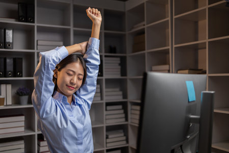 Company employees working overtime after work, working overtime after working hours due to heavy workload, employees are stressed and tired from working hard all day and continuously working overtime.の写真素材