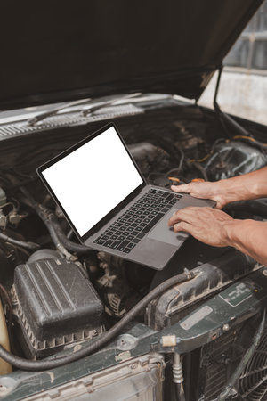 Car mechanic is inspecting the engine of a car coming in for repair at the center. Professional engine specialist, car repair, car breakdown. Car maintenance and repair concept.の写真素材