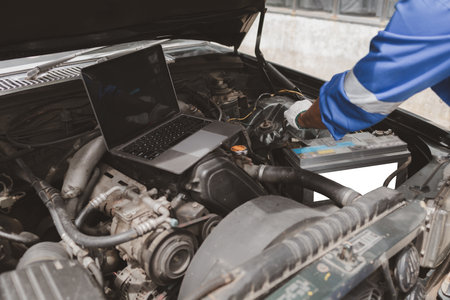 Car mechanic is inspecting the engine of a car coming in for repair at the center. Professional...