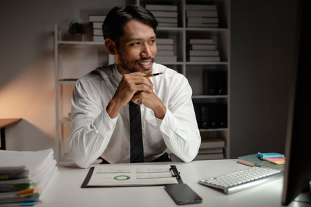 A man works overtime in a startup company office in the middle of the night, he works hard after work, company employee overtime. Concept of overtime and hard work.の写真素材