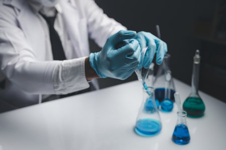 Lab assistant, a medical scientist, a chemistry researcher holds a glass tube through the blood...