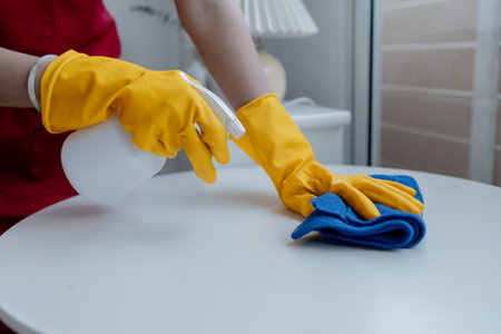Asian woman cleaning staff, housekeeper cleaning tables in a company office, maintaining cleanliness in the office. Cleaning concept and housekeeper taking care of cleanliness and order in the office.の写真素材