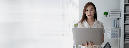 Young Asian woman, businesswoman in finance, businesswoman working in finance, planning finances for a startup company and reviewing financial statements. Financial management concepts.の写真素材