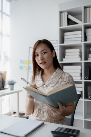 Young Asian woman, businesswoman in finance, businesswoman working in finance, planning finances for...