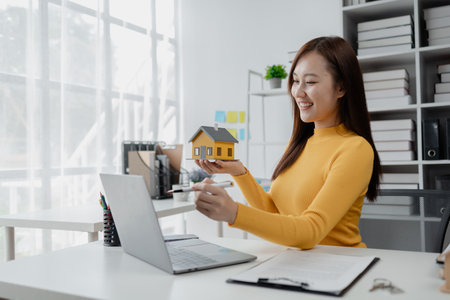 Housing project sales staff make sales presentations of various types of houses. to customers who visit and explain trading details. Home and real estate salesperson concept.の写真素材