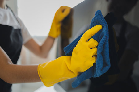 Cleaner is working, Wear rubber gloves and an apron to work, Cleaning staff wiping down office...
