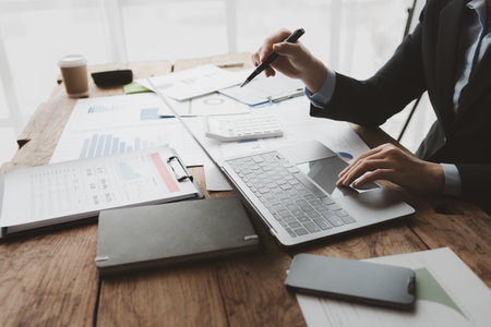Accountant calculating numbers on calculator, Auditor is working on accounting in the office, Businessman calculating the financial liquidity of the company, accounting idea.の写真素材