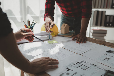 engineer is in planning meeting with architect about building a house,  Draw structural of buildings at the meeting and discuss together,  Design blueprints for use in structural work, architect idea.の写真素材