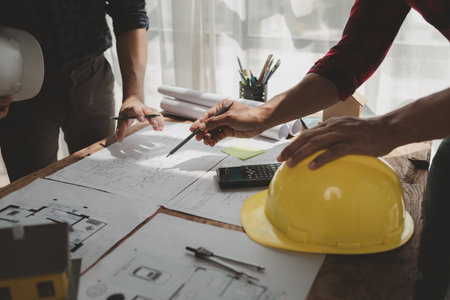 engineer is in planning meeting with architect about building a house,  Draw structural of buildings at the meeting and discuss together,  Design blueprints for use in structural work, architect idea.の写真素材