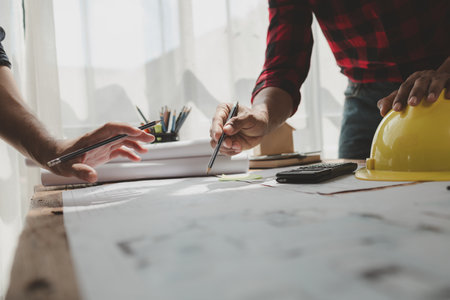 engineer is in planning meeting with architect about building a house,  Draw structural of buildings at the meeting and discuss together,  Design blueprints for use in structural work, architect idea.の写真素材