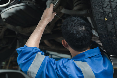 The mechanic is repairing the engine, A car repair worker is inspecting a car, A car mechanic is looking at what is the problem with the engine in the garage.の写真素材